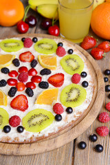 Fototapeta na wymiar Sweet pizza with fruits on table close-up