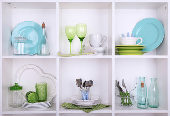 Kitchen utensils and tableware on beautiful white shelves