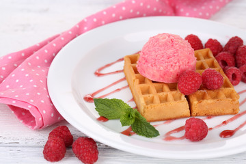 Tasty belgian waffles with ice cream on wooden table