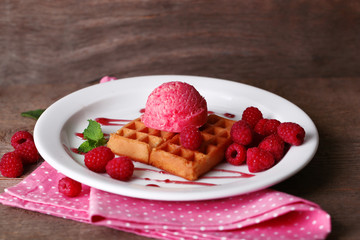 Tasty belgian waffles with ice cream on wooden table