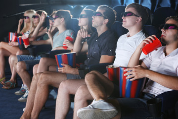 Obraz premium Young people watching movie in cinema