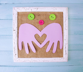 Wooden frame with paper arms and colorful buttons