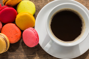 French colorful macarons with cup of coffee