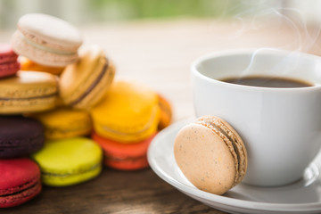 French colorful macarons with cup of coffee