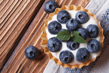 Tartlets with blueberries on wooden view from above