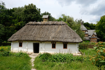Fototapeta na wymiar White traditional Ukrainian rural wooden house with hay roof