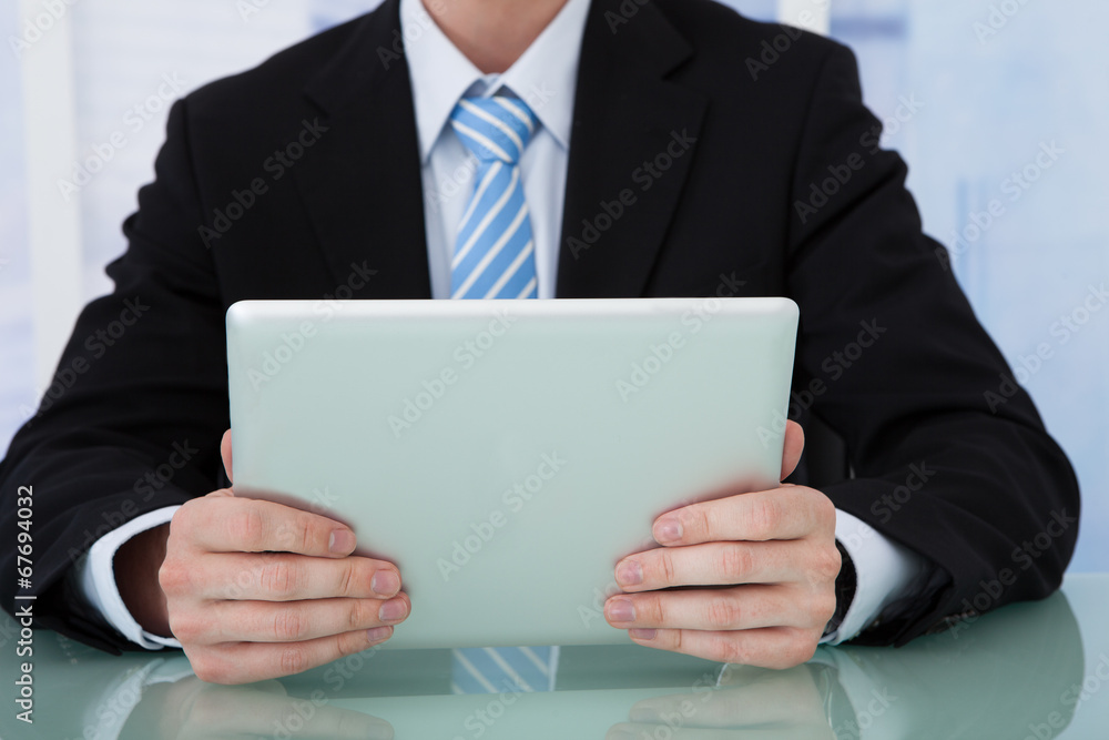 Poster businessman using tablet computer at desk