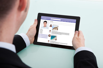 Businessman Surfing Social Networking Site On Digital Tablet