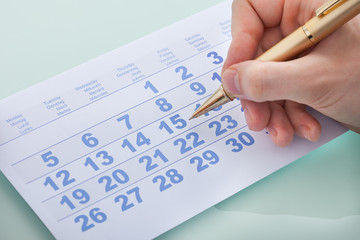 Hand Marking Date 15 On Calendar