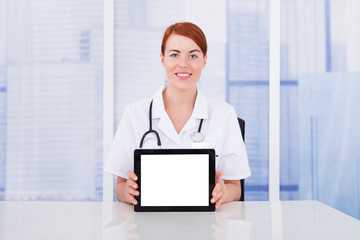 Young Doctor Displaying Digital Tablet At Desk