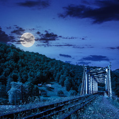 old railroad passes in mountain village at night