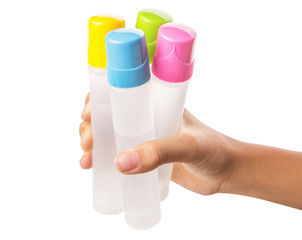 Female teenage hand holding colorful glue bottles 