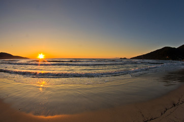 Fototapeta na wymiar Sunrise and waves at the golden beach, Thassos island
