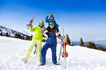 Mom, dad with child on his shoulders in ski masks