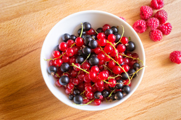 Raspberry, Red and Black Currant on Wood Background.