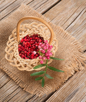 fresh and dried pink pepper in a small basket
