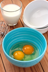 Eggs in a blue bowl and a glass of milk