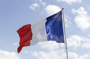 Naklejka na ściany i meble Blowing French Flag on Blue Sky Background