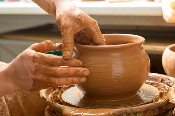 hands of a potter, creating an earthen jar