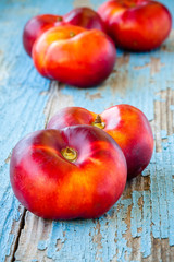 fresh organic flat nectarines on an old wooden background