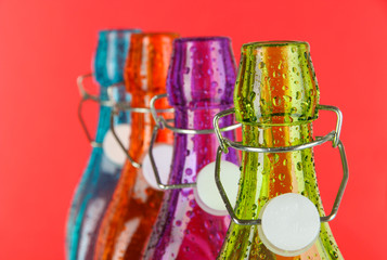 Colorful bottles on red background