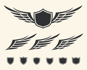 Vector set of isolated winged crests over white background.
