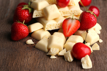 Broken white chocolate bar with fresh strawberries,