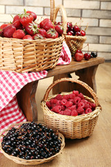 Fresh berries in basket on wall background