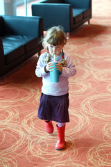 Little girl with pigtails drinking soda from plastic tube