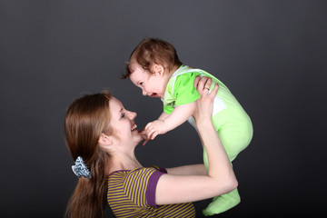 Portrait of happy mother playing with her cute little son