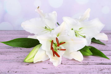 Beautiful lily on table on bright background