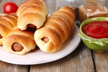 Baked sausage rolls on plate on table close-up