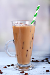 Glass of iced milk coffee on light background