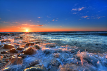 Sunset over the Baltic sea. The pebbly beach in Rozewie