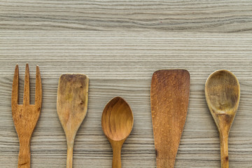 Kitchen wooden utensil of scapula, spoon and fork on Wooden Background