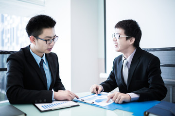 Two Businessmen Having Informal Meeting In Modern Office