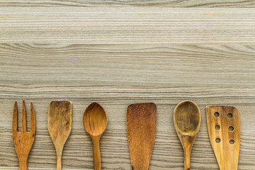 Kitchen wooden utensil of scapula, spoon and fork with copy space