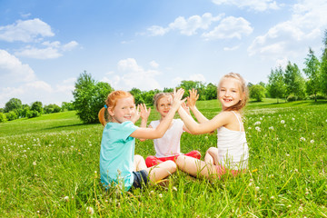 Fototapeta premium Three kids playing on a grass