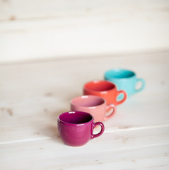 Colorful coffee cups over wooden background