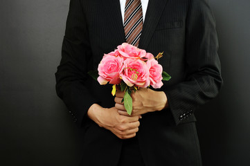 ピンクの花束を持っているスーツのビジネスマン