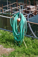Tuyau vert enroul&eacute; devant un &eacute;chafaudage de chantier