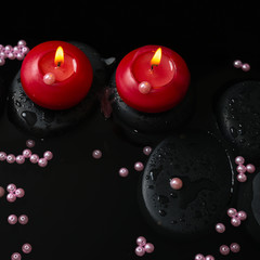 Beautiful spa still life of candles, zen stones with drops and p