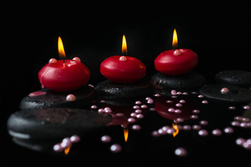 Beautiful spa concept of candles, zen stones with drops and pear
