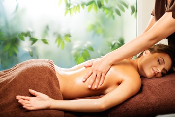 Beautiful young woman having massage in a spa salon