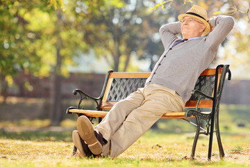 Relaxed pensioner sitting on bench in park