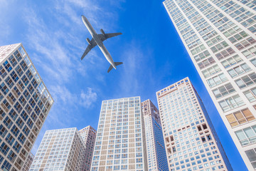 Fototapeta na wymiar Airplane flying in business district sky,motion,blur