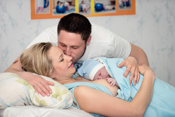 Young beautiful woman with a newborn baby after birth - obrazy, fototapety, plakaty