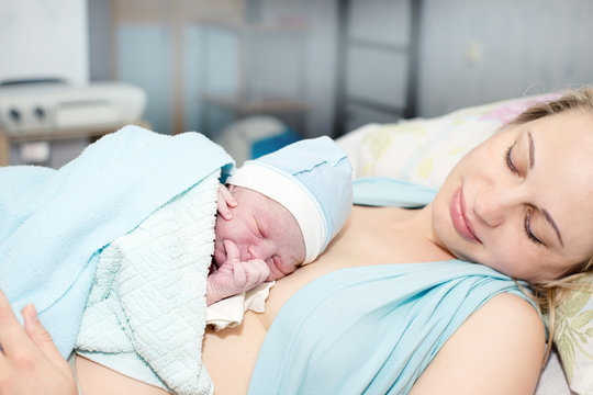 Young Beautiful Woman With A Newborn Baby After Birth