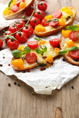 Tasty bruschetta with tomatoes, on old wooden table