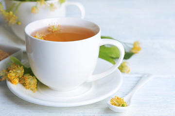 Tasty herbal tea with linden flowers on wooden table